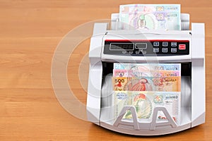 Surinamese guilder in a counting machine photo