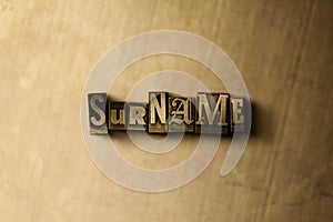 SURNAME - close-up of grungy vintage typeset word on metal backdrop