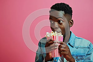 Surprise African Yearold Man Eats Popcorn On Pastel Background photo