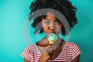 Surprise African Yearold Woman Eats Mint Chocolate Chip Ice Cream On Turquoise Background photo