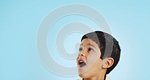 Surprise, boy and child with decision, opportunity and fantasy on a blue studio background. Person, mockup space and