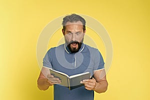 Surprise concept. Bearded man shocked with surprise. Senior man reading book with surprise. Real surprise