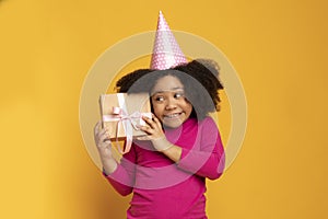 Surprise Gift. Cute Little African American Birthday Girl Shaking Present Box