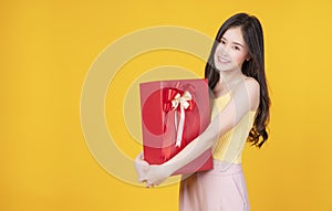 Surprise greeting anniversary birthday or celebration christmas and new year. Cheerful excited young woman holding red gift box