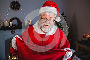 Surprise santa claus opening gift sack in living room