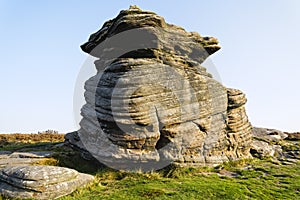 Autumn sunlight shines on the Mother Cap gritstone outcrop photo