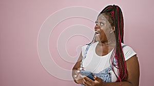 Surprised african american woman with a cool smile, joyfully looks over while texting on her phone, enjoying her casual lifestyle