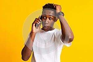 Surprised african man found out something talking on cell phone