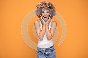 Surprised amazed beautiful afro woman with wide open smiling mouth.