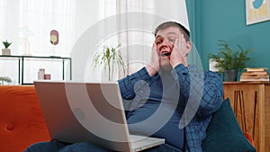 Surprised amazed man using laptop computer, receive mail good news message wow shocked win app game