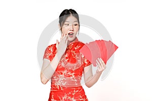 Surprised Asian woman wearing traditional cheongsam qipao dress holding angpao or red packet monetary gift isolated on white