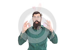 surprised bearded man wear bunny ears on easter holiday hold painted eggs isolated on white, easter.