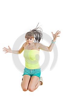 surprised beautiful cute young woman or girl in blank green t-shirt and shorts jumps with face expression over white