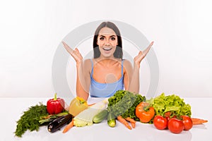 Surprised beautiful girl on a diet with vegetables on the table