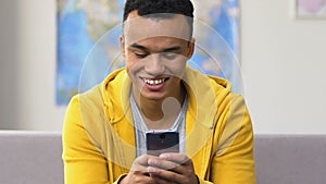 Surprised black high schooler browsing smartphone, modern dating social apps