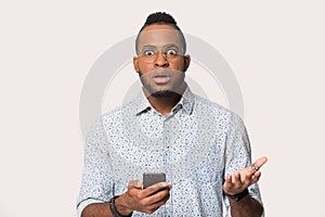Surprised black man confused by unexpected message on smartphone