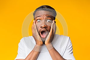 Surprised Black Man Touching Face Posing Over Orange Background