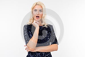 Surprised blonde girl in a blue beautiful elegant dress on a white background with copy space