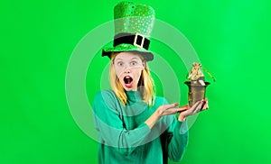 Surprised blonde woman in Leprechaun costume with pot of gold. Saint Patrick's Day celebration. Irish Traditions