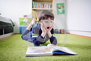 Surprised boy is discovering something from the book