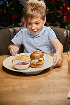 Surprised boy looking at big burger saying wow on New year celebration