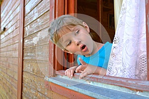 The surprised boy looks out of the window