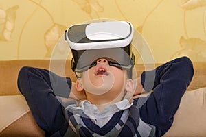 Surprised boy with open mouth watching a 3D video through VR glasses