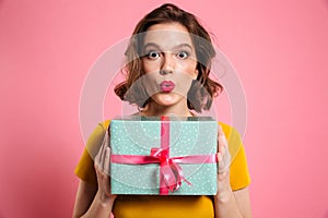 Surprised brunette woman with bright makeup holding present, loo