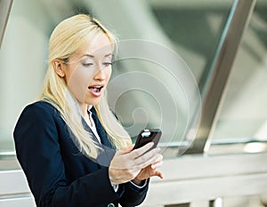 Surprised business woman reading something on her smart phone