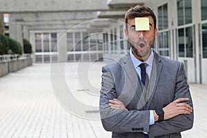 Surprised businessman with a note on his forehead