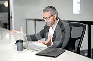 Surprised businessman working with laptop in office. Surprised business man using laptop. Surprised man using laptop at