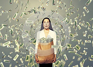 Surprised businesswoman holding money