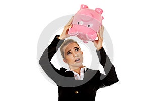 Surprised businesswoman holding a piggybank