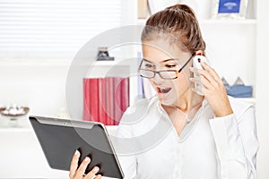 Surprised businesswoman looking at tablet computer