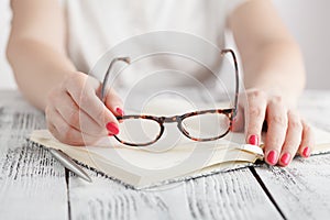 Surprised businesswoman taking off glasses while reading in office