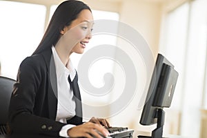 Surprised Businesswoman Working On Desktop PC