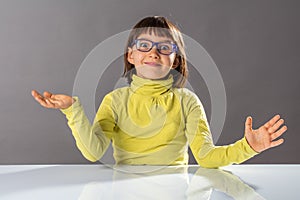Surprised cheerful child with eyeglasses enjoying thrilled hand gesture photo