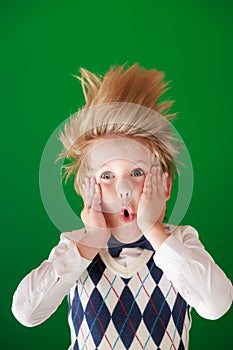 Surprised child against green chalkboard in class