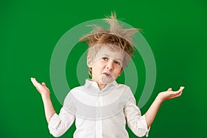 Surprised child against green chalkboard in class