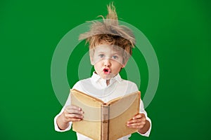 Surprised child against green chalkboard in class