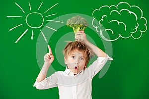 Surprised child against green chalkboard in class