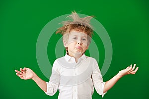 Surprised child against green chalkboard in class