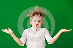 Surprised child against green chalkboard in class