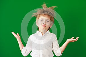 Surprised child against green chalkboard in class