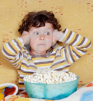 Surprised child with a bowl full of popcorn