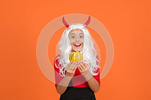 Surprised child celebrate autumn holiday with traditional food. teenage girl in devil horns celebrate halloween. happy