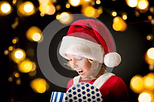 Surprised child holding Christmas gift box