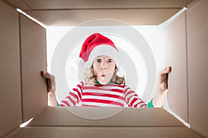 Surprised child unpack Christmas gift box