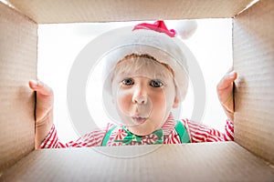 Surprised child unpack Christmas gift box