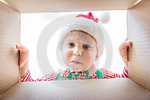 Surprised child unpack Christmas gift box